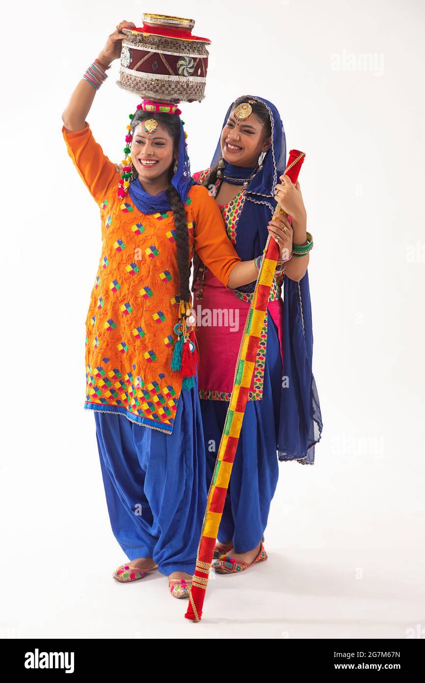Due ballerini Giddha in piedi insieme con matki e bastone decorati. Foto Stock