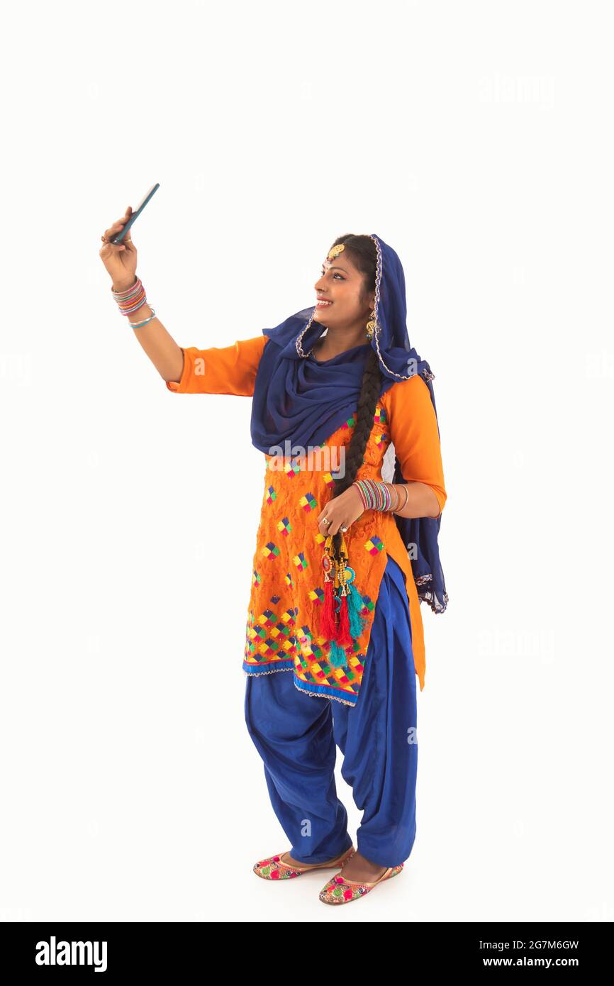 Una donna che indossa il costume di Giddha cliccando un selfie. Foto Stock