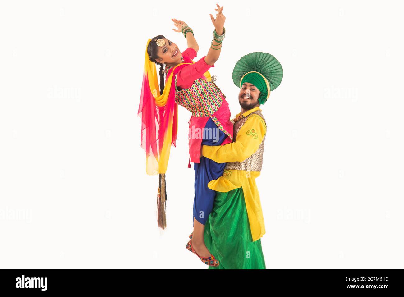 Un ballerino di Bhangra che solleva un ballerino di Giddha raffigurante un passo di danza. Foto Stock