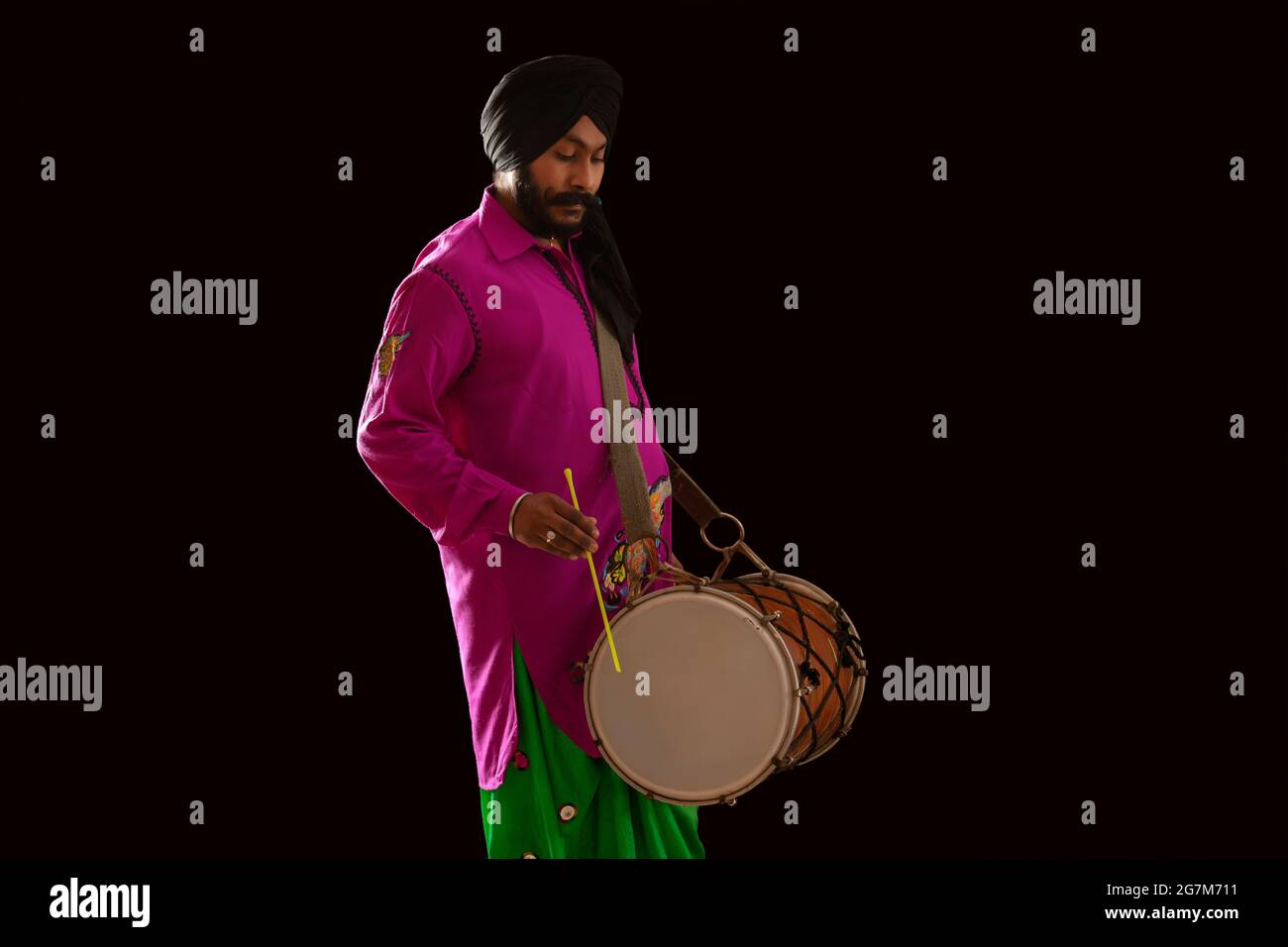 Un ballerino di Bhangra che batte un Dhol. Foto Stock