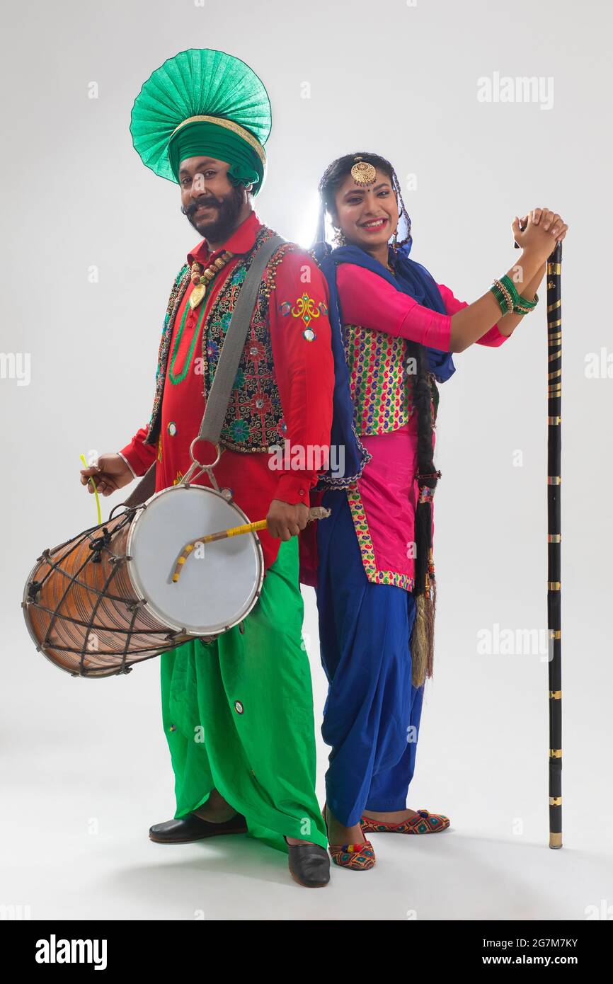 Un Bhangra e UN ballerino di Giddha che suonano con un Dhol e un Khunda. Foto Stock