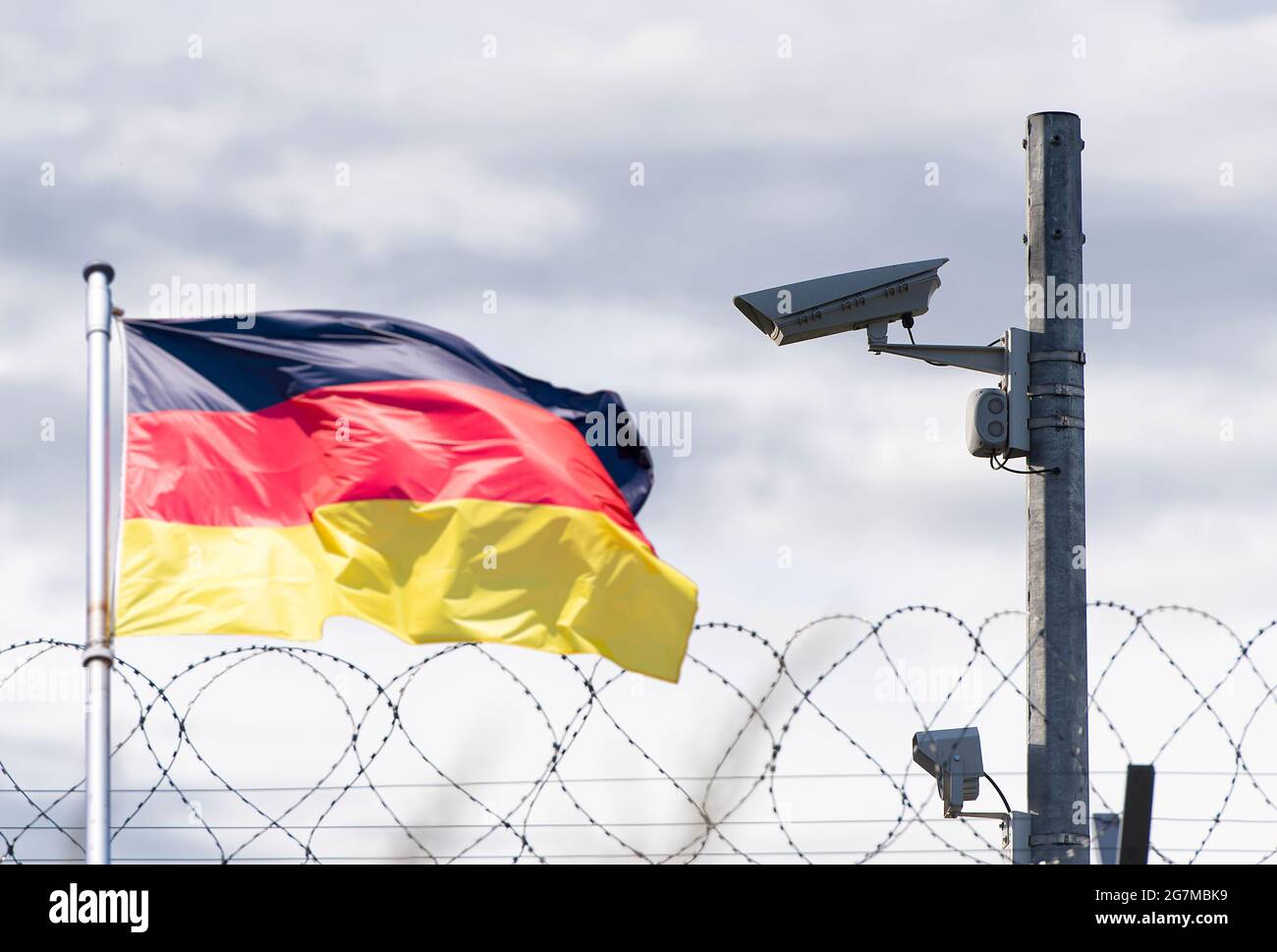 Confine con la Germania, ambasciata, telecamera di sorveglianza, filo spinato e bandiera della Germania, immagine concettuale Foto Stock