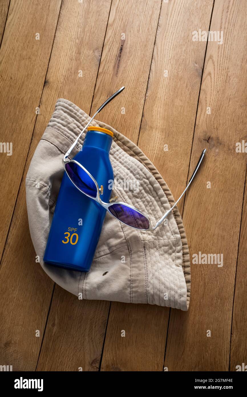 Cappello di cotone, occhiali da sole e crema solare. Foto Stock