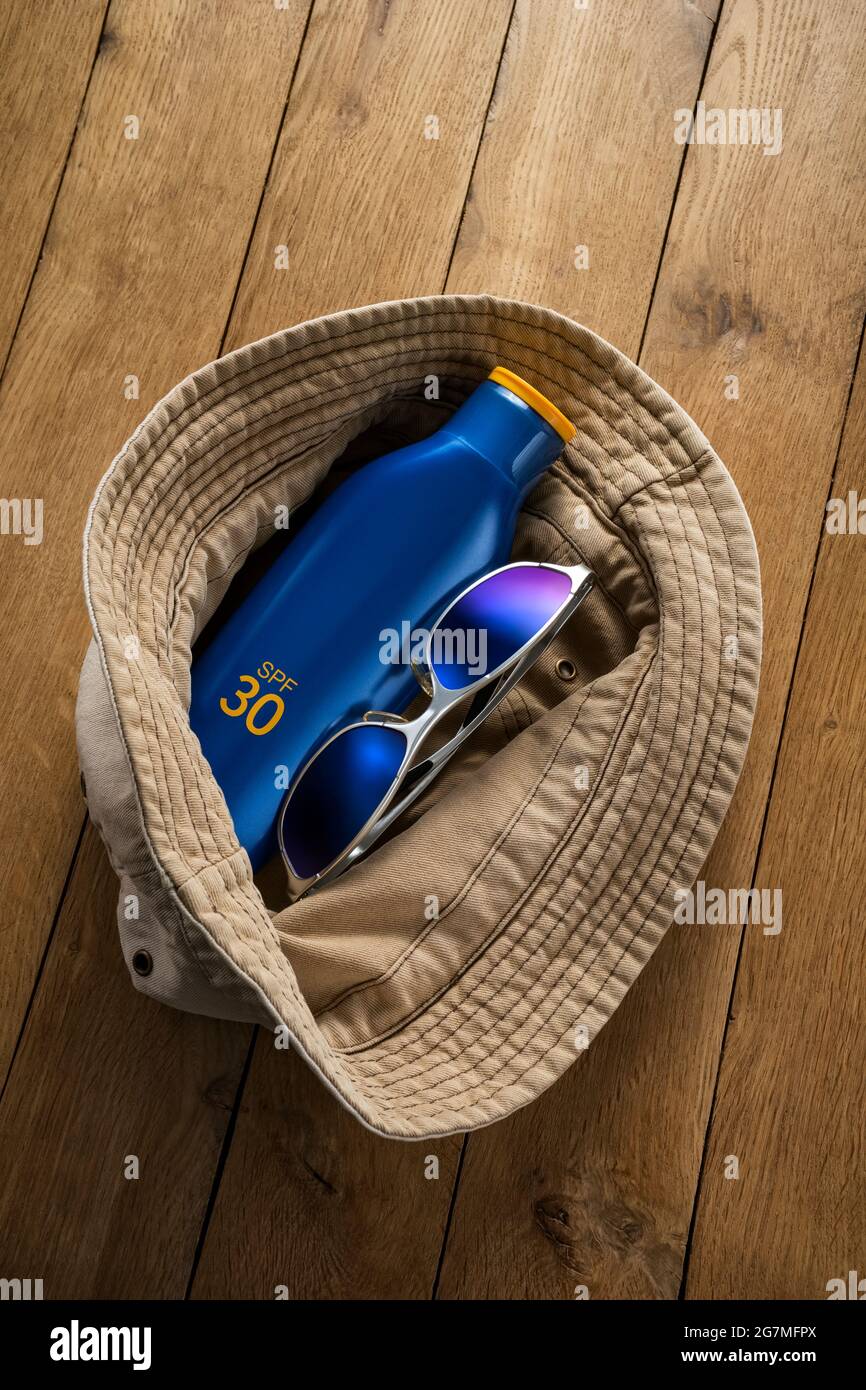 Cappello di cotone, occhiali da sole e crema solare. Foto Stock