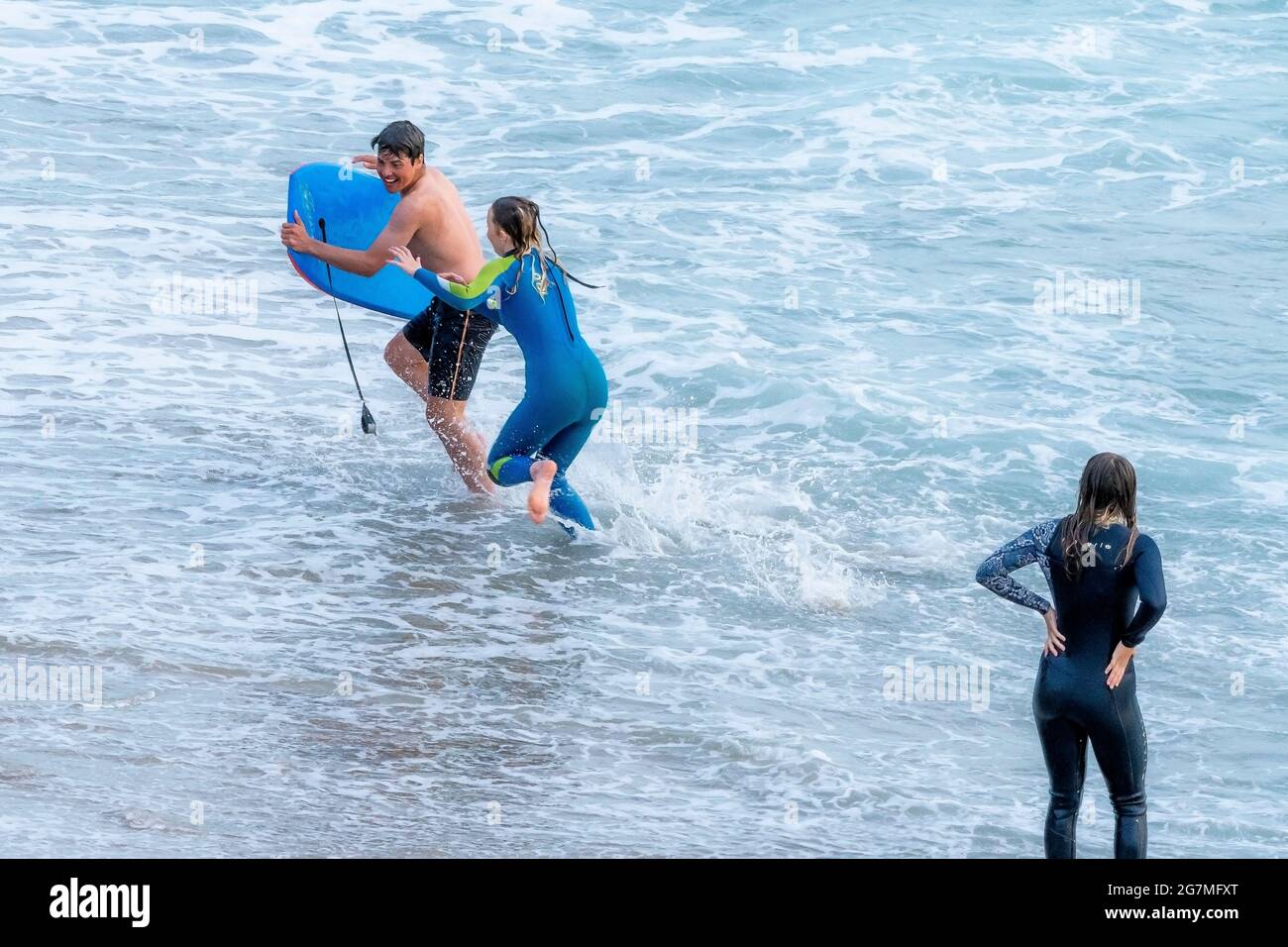 Giovani adolescenti che giocano in mare a Little Fistral a Newquay in Cornovaglia. Foto Stock