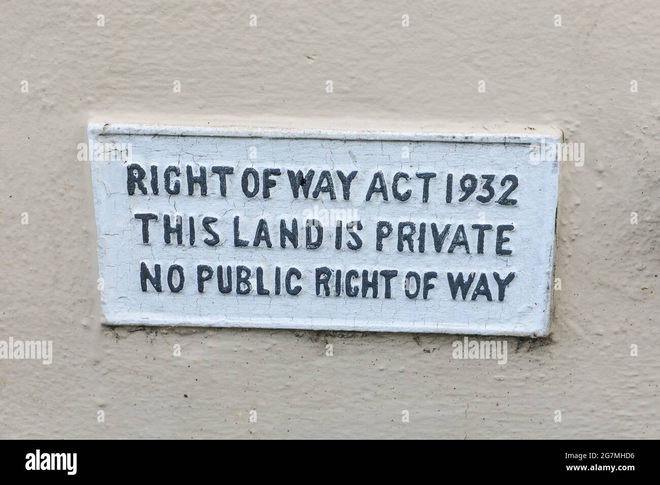 Un cartello su un muro che dice 'Right of Way Act 1932 questa terra è privata, nessun diritto pubblico di modo', Inghilterra, Regno Unito Foto Stock