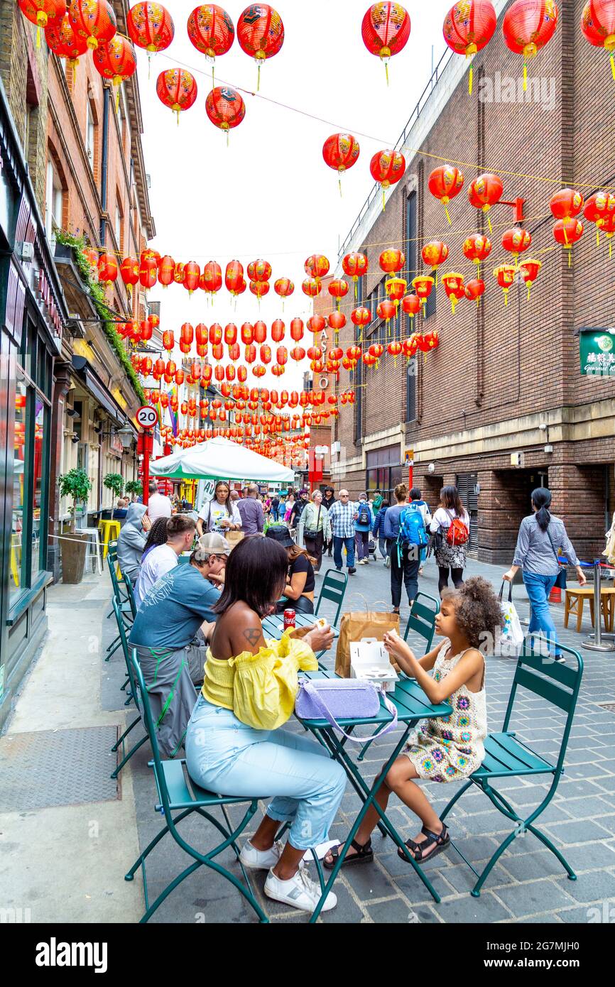 La gente cena all'aperto al ristorante Bun House bao su Lisle Street, Chinatown, Londra, Regno Unito Foto Stock