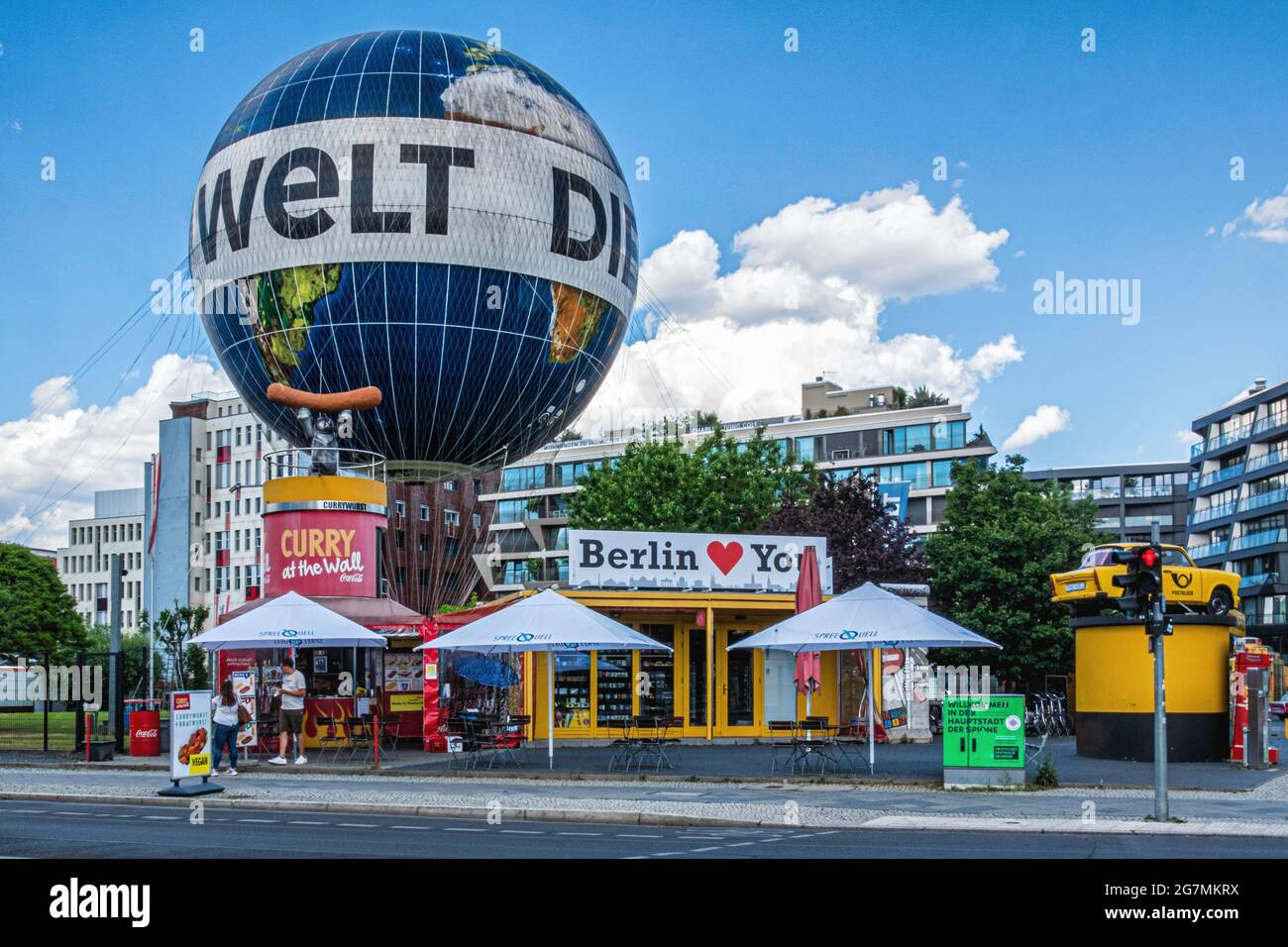Bancarella di fast food curry Wurst, giro in mongolfiera e auto gialla Trabi. Attrazioni turistiche a Mitte, Berlino, Germania. Foto Stock