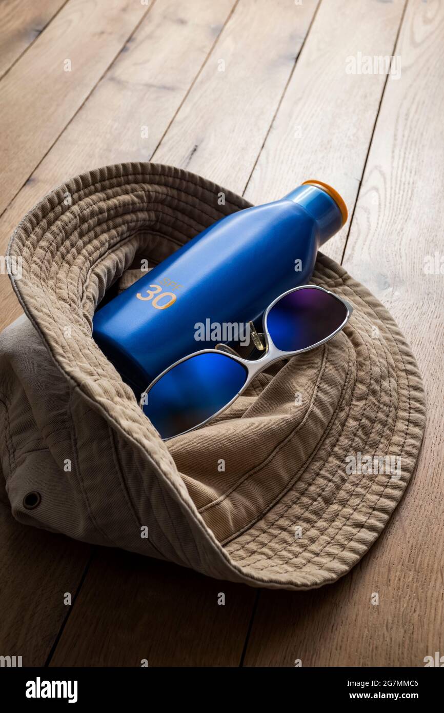 Cappello di cotone, occhiali da sole e crema solare. Foto Stock