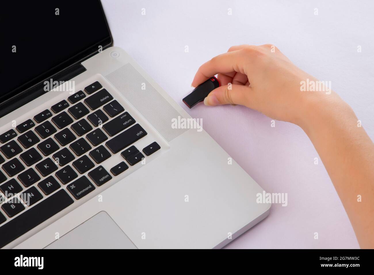 Mano umana che inserisce l'unità penna nel laptop. Foto Stock