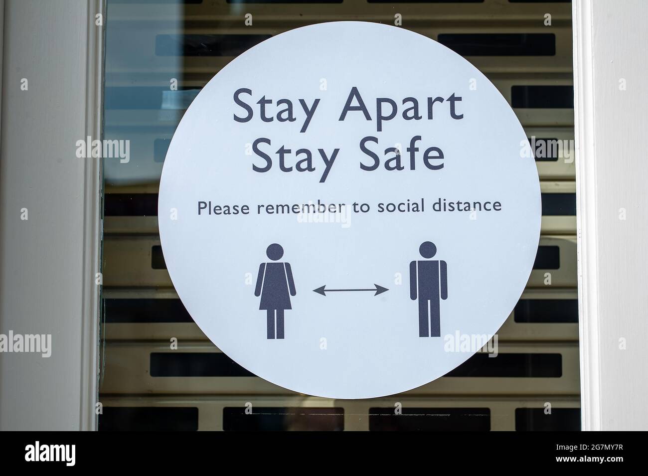 Windsor, Berkshire, Regno Unito. 14 luglio 2021. Un avviso di soggiorno separato Covid-19 in una vetrina a Windsor. 1200 scienziati e medici si sono espressi contro la rimozione di distanza sociale e l'obbligo legale di indossare maschere facciali, mentre in negozi da lunedì 19 luglio 2021, in quanto temono che questo aumenterà il numero crescente di casi Covid-19 ancora di più. Credito: Maureen McLean/Alamy Foto Stock
