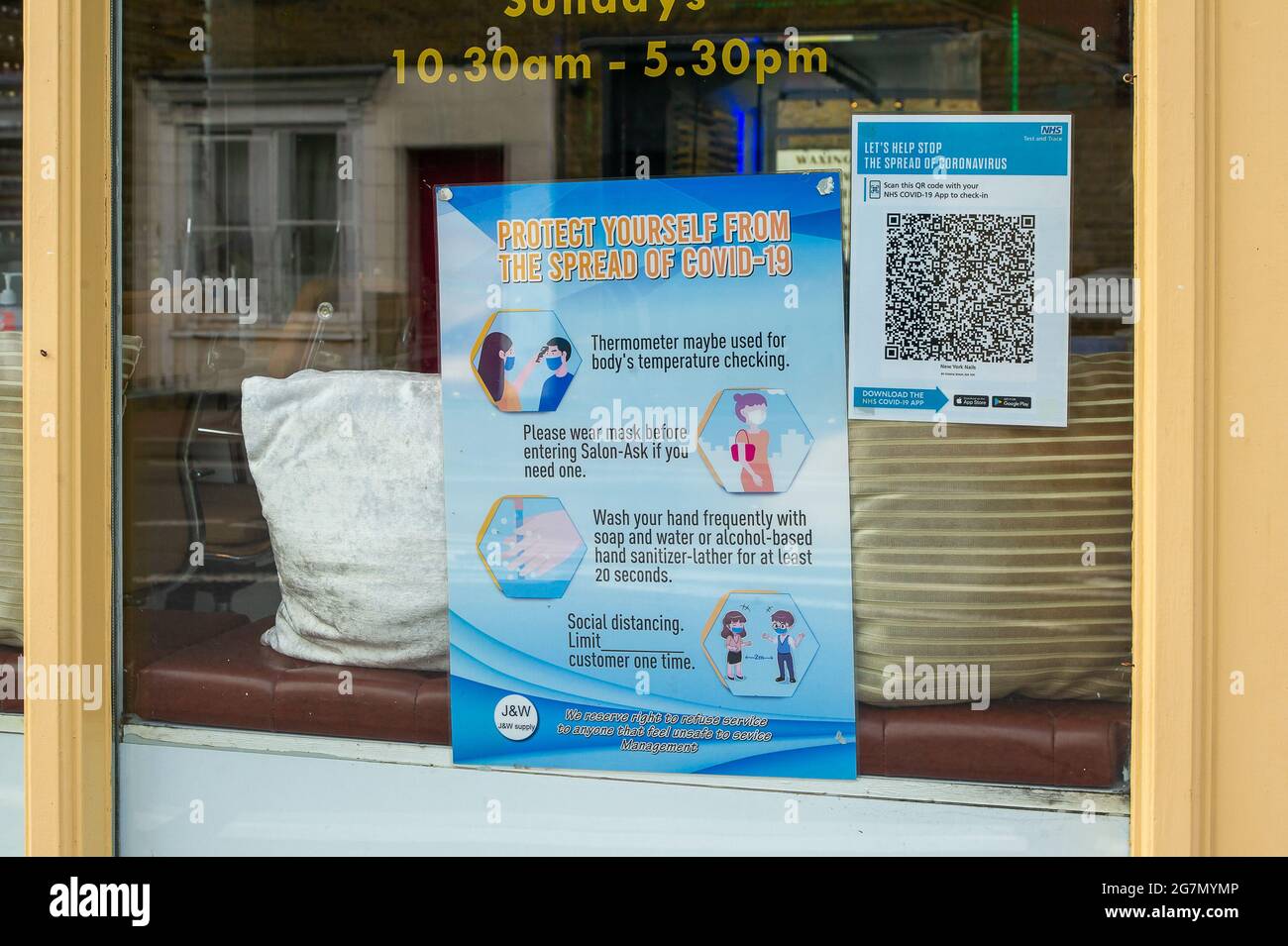 Windsor, Berkshire, Regno Unito. 14 luglio 2021. Un avviso di traccia e traccia Covid-19 in una finestra di un salone a Windsor. 1200 scienziati e medici si sono espressi contro la rimozione di distanza sociale e l'obbligo legale di indossare maschere facciali, mentre in negozi da lunedì 19 luglio 2021, in quanto temono che questo aumenterà il numero crescente di casi Covid-19 ancora di più. Credito: Maureen McLean/Alamy Foto Stock