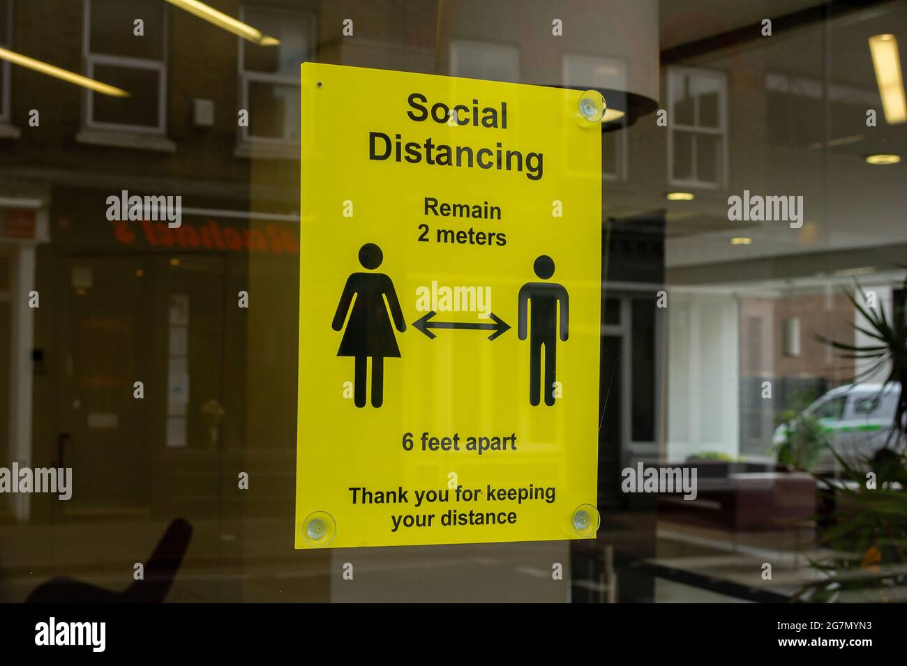 Windsor, Berkshire, Regno Unito. 14 luglio 2021. Un avviso di allontanamento sociale Covid-19 in una vetrina a Windsor. 1200 scienziati e medici si sono espressi contro la rimozione di distanza sociale e l'obbligo legale di indossare maschere facciali, mentre in negozi da lunedì 19 luglio 2021, in quanto temono che questo aumenterà il numero crescente di casi Covid-19 ancora di più. Credito: Maureen McLean/Alamy Foto Stock