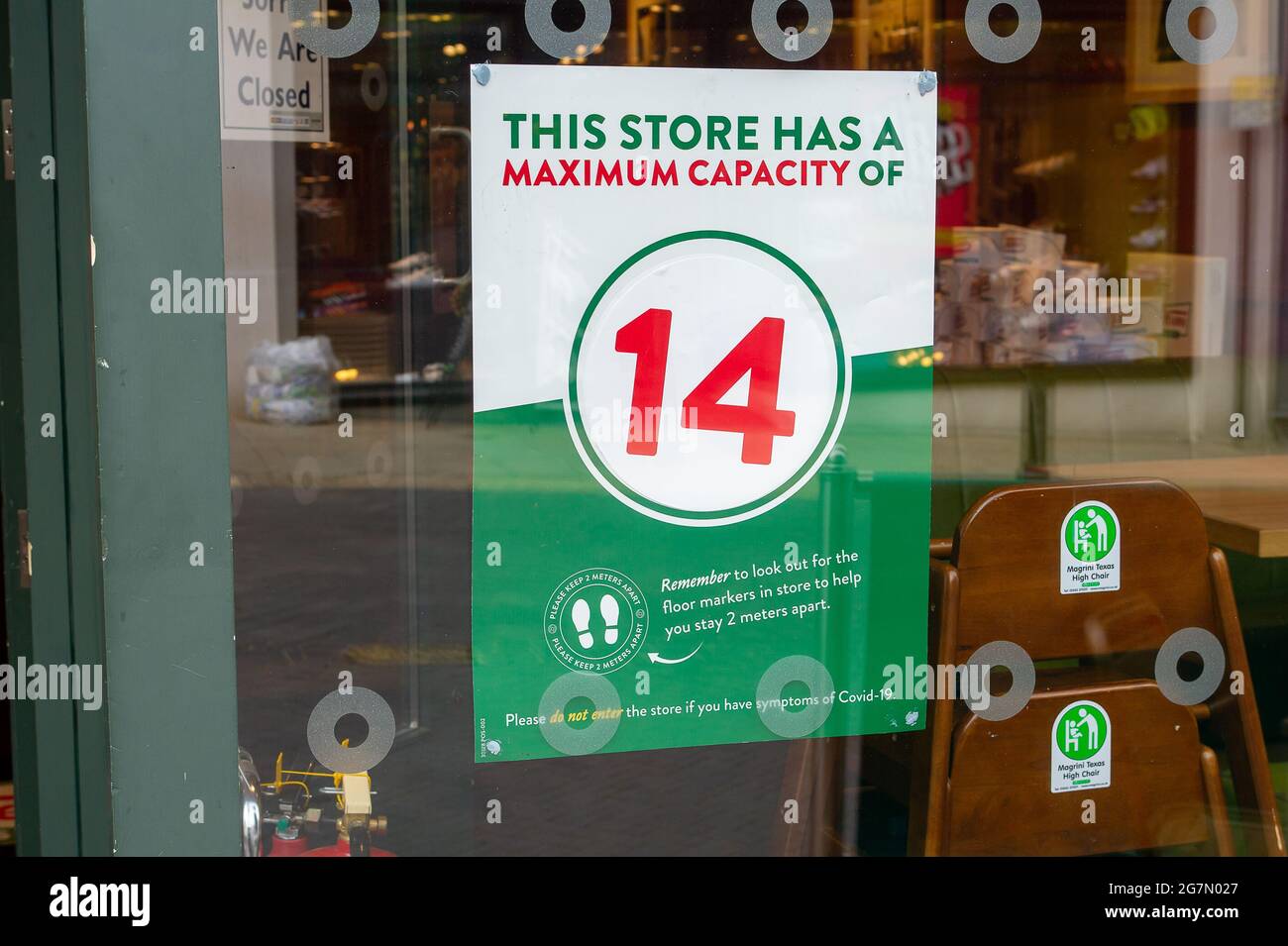 Windsor, Berkshire, Regno Unito. 14 luglio 2021. Un avviso di capacità massima del Covid-19 in una vetrina a Windsor. 1200 scienziati e medici si sono espressi contro la rimozione di distanza sociale e l'obbligo legale di indossare maschere facciali, mentre in negozi da lunedì 19 luglio 2021, in quanto temono che questo aumenterà il numero crescente di casi Covid-19 ancora di più. Credito: Maureen McLean/Alamy Foto Stock