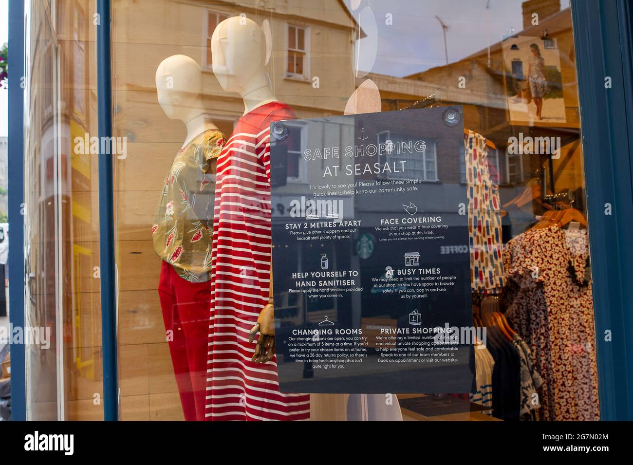 Windsor, Berkshire, Regno Unito. 14 luglio 2021. Un Covid-19 misura un avviso in una vetrina di abbigliamento da donna a Windsor. 1200 scienziati e medici si sono espressi contro la rimozione di distanza sociale e l'obbligo legale di indossare maschere facciali, mentre in negozi da lunedì 19 luglio 2021, in quanto temono che questo aumenterà il numero crescente di casi Covid-19 ancora di più. Credito: Maureen McLean/Alamy Foto Stock