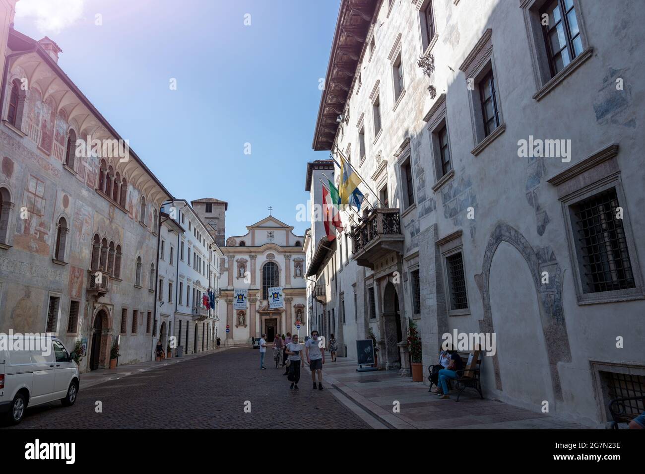 Trento, Italia, giugno 2021. Uno degli edifici storici del centro è caratterizzato da una facciata finemente affrescata. Sullo sfondo la Chiesa di SA Foto Stock