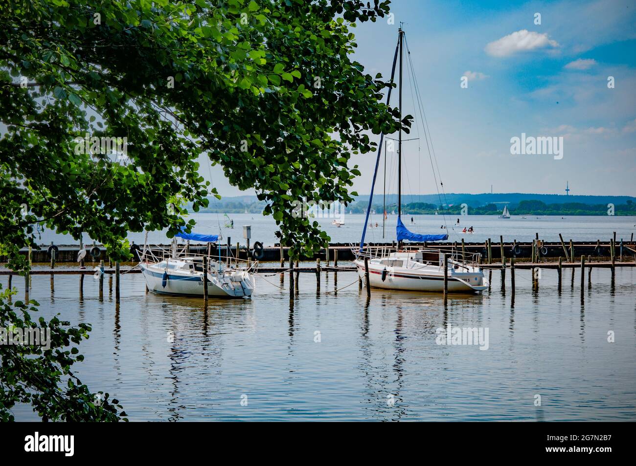 BOHMTE, GERMANIA. 27 GIUGNO 2021 Parco Naturale di Dammer. Vista sul lago, barche, yacht, gente del molo che riposa sulla spiaggia Foto Stock