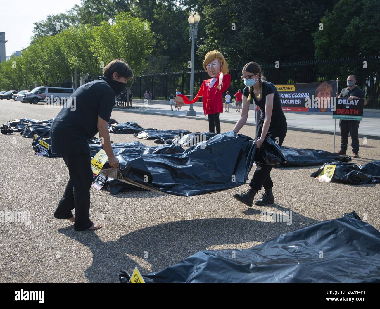 Washington, Stati Uniti. 15 luglio 2021. Public Citizen's Global Trade Watch tiene una protesta fuori dalla Casa Bianca il giorno della visita della cancelliera tedesca Angela Merkel con il presidente Biden a Washington, DC., giovedì 15 luglio 2021. Le borse per il corpo, che rappresentano il numero globale di decessi COVID-19 da quando la rinuncia ai diritti di proprietà intellettuale legati al commercio (TRIPS) è stata proposta per la prima volta nell'ottobre 2020, giacciono sotto un burattino oversize della Merkel, che ha bloccato la rinuncia TRIPS in Germania. Foto di Bonnie Cash/UPI Credit: UPI/Alamy Live News Foto Stock