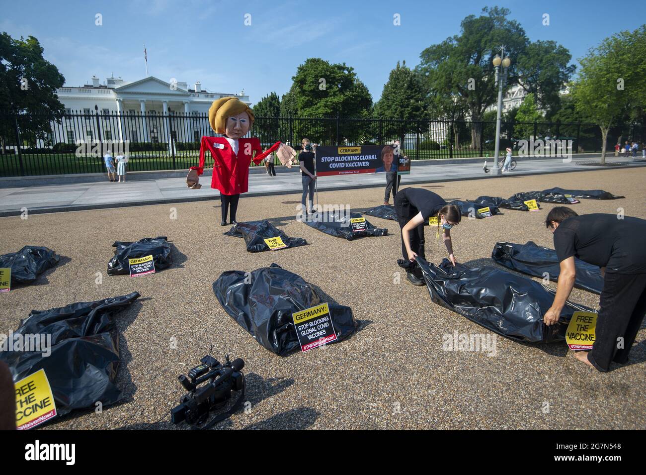 Washington, Stati Uniti. 15 luglio 2021. Public Citizen's Global Trade Watch tiene una protesta fuori dalla Casa Bianca il giorno della visita della cancelliera tedesca Angela Merkel con il presidente Biden a Washington, DC., giovedì 15 luglio 2021. Le borse per il corpo, che rappresentano il numero globale di decessi COVID-19 da quando la rinuncia ai diritti di proprietà intellettuale legati al commercio (TRIPS) è stata proposta per la prima volta nell'ottobre 2020, giacciono sotto un burattino oversize della Merkel, che ha bloccato la rinuncia TRIPS in Germania. Foto di Bonnie Cash/UPI Credit: UPI/Alamy Live News Foto Stock