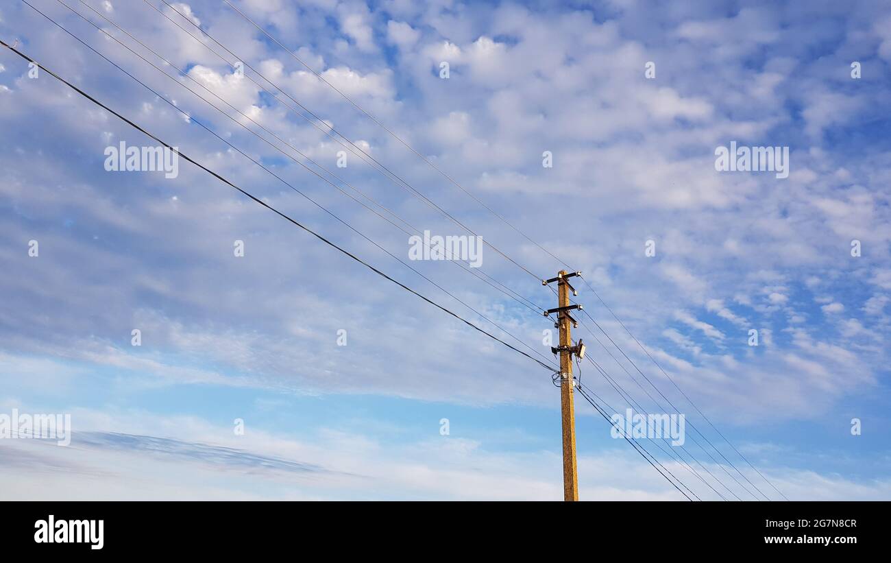 Palo elettrico su cielo blu nuvoloso con nuvole di perle. Foto Stock