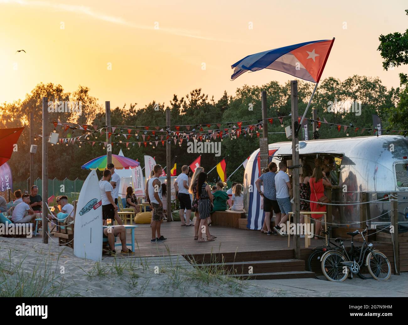 Parnu, Estonia - 06.21.2021: Piccolo cocktail bar vicino alla spiaggia chiamato Little Cuba. La gente si è schierata per comprare le bevande economiche vicino alla spiaggia. Perfetta atmosfera al tramonto a Parnu, capitale Estone estiva. Festa in spiaggia. Foto Stock