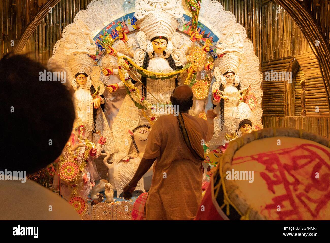 KOLKATA , INDIA - 27 SETTEMBRE 2017 : il sacerdote indù adorava la dea Durga mentre dhaakis (batteristi) si esibiva nel suo backside. Durga Puja festival Foto Stock