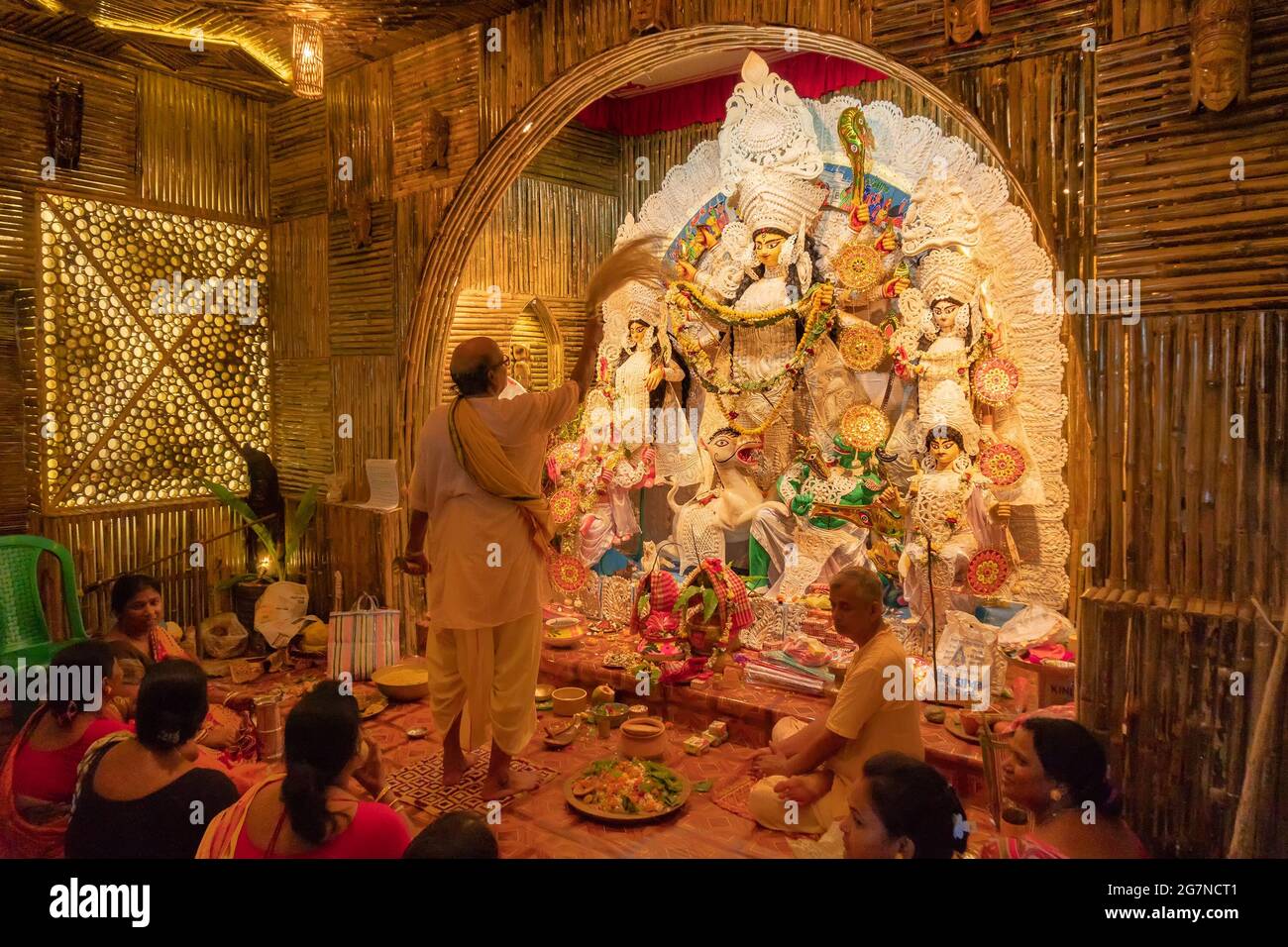 KOLKATA , INDIA - 27 SETTEMBRE 2017 : il sacerdote indù adorava la dea Durga mentre dhaakis (batteristi) si esibiva nel suo backside. Durga Puja festival Foto Stock