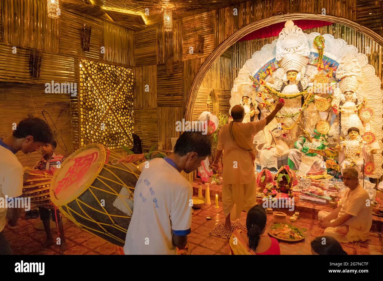 KOLKATA , INDIA - 27 SETTEMBRE 2017 : il sacerdote indù adorava la dea Durga mentre dhaakis (batteristi) si esibiva nel suo backside. Durga Puja festival Foto Stock