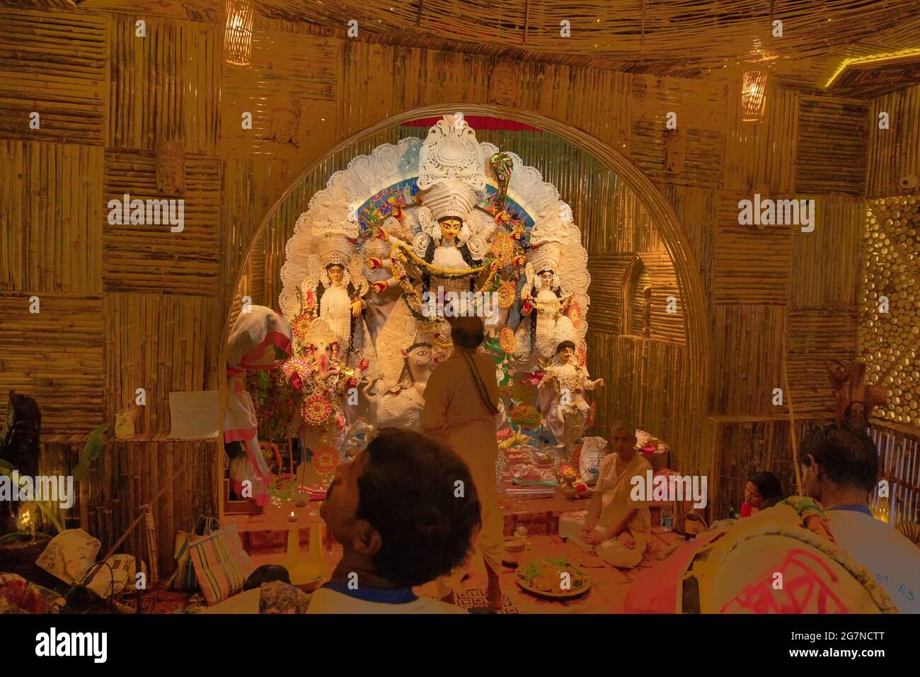 KOLKATA , INDIA - 27 SETTEMBRE 2017 : il sacerdote indù adorava la dea Durga mentre dhaakis (batteristi) si esibiva nel suo backside. Durga Puja festival Foto Stock