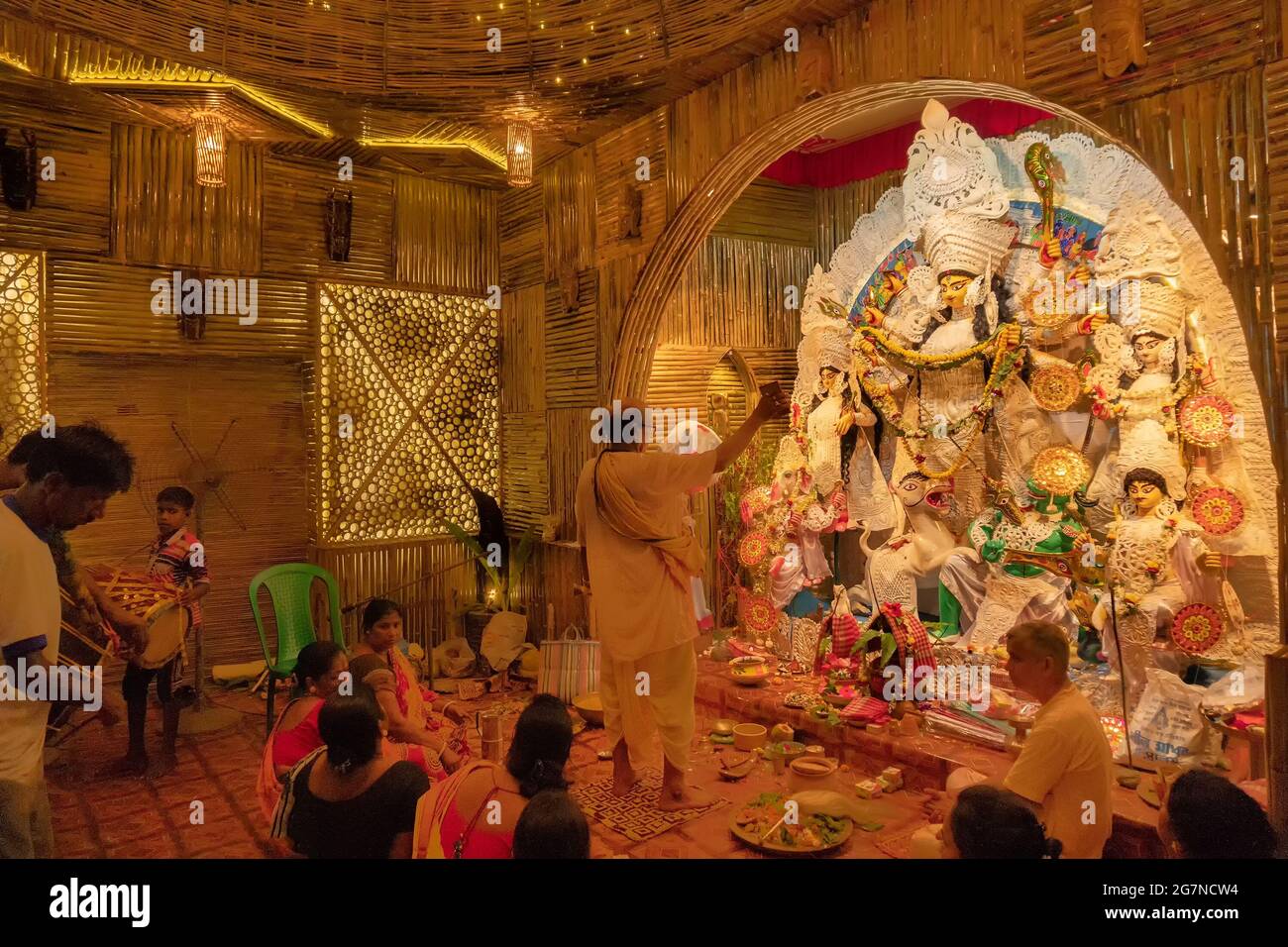 KOLKATA , INDIA - 27 SETTEMBRE 2017 : il sacerdote indù adorava la dea Durga mentre dhaakis (batteristi) si esibiva nel suo backside. Durga Puja festival Foto Stock