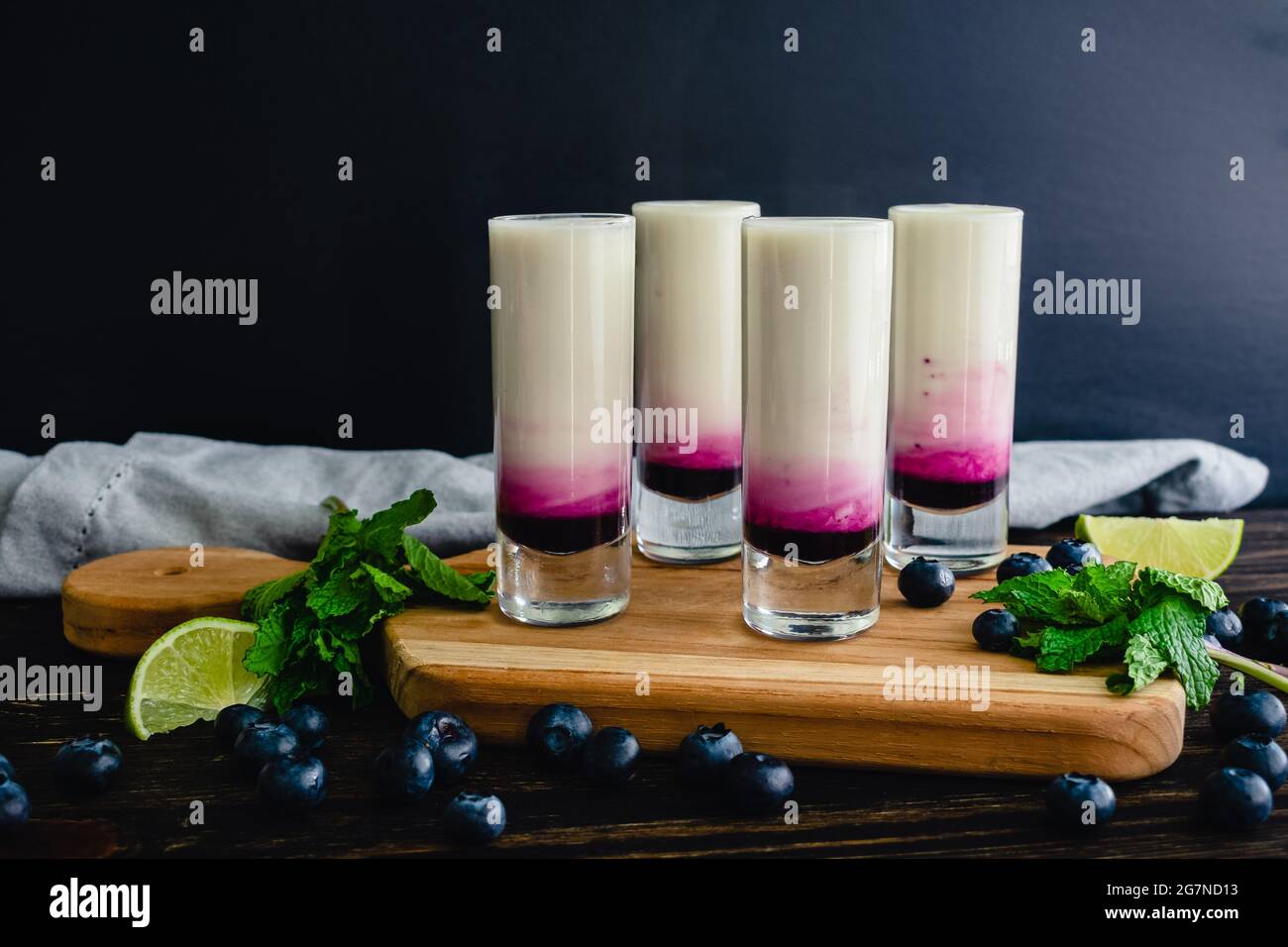 Coconut Lime Mojito Shooters con mirtillo: Mojito di cocco colpi stratificati con sciroppo di mirtillo Foto Stock