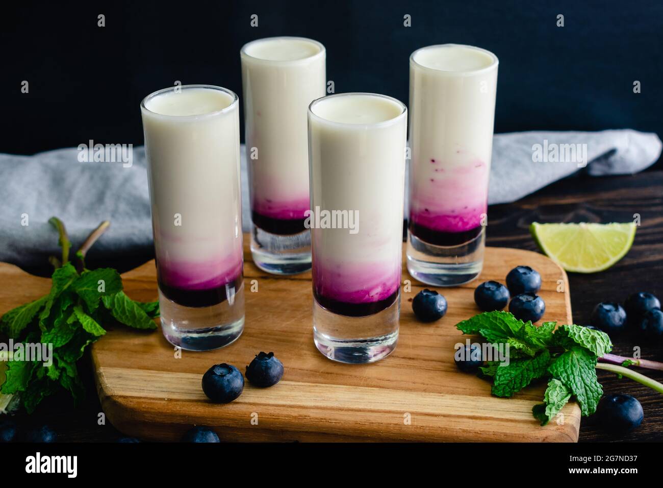 Coconut Lime Mojito Shooters con mirtillo: Mojito di cocco colpi stratificati con sciroppo di mirtillo Foto Stock