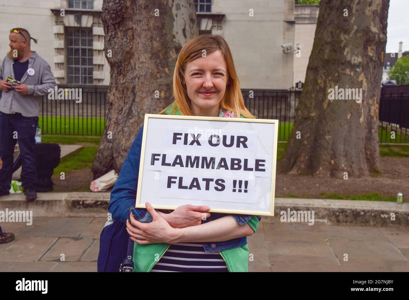 Londra, Regno Unito. 15 luglio 2021. Un dimostratore ha in mano un cartello con la scritta "Fix our Flats Flats" (ripara i nostri appartamenti infiammabili) durante la protesta contro la crisi della sicurezza dell'edificio. Gli inquilini e i locatari si sono riuniti fuori Downing Street per chiedere al governo britannico e agli sviluppatori di pagare per la rimozione di rivestimenti pericolosi e per il miglioramento della sicurezza antincendio negli edifici, una questione che è rimasta di vitale importanza dal disastro di Grenfell nel 2017. (Foto di Vuk Valcic/SOPA Images/Sipa USA) Credit: Sipa USA/Alamy Live News Foto Stock