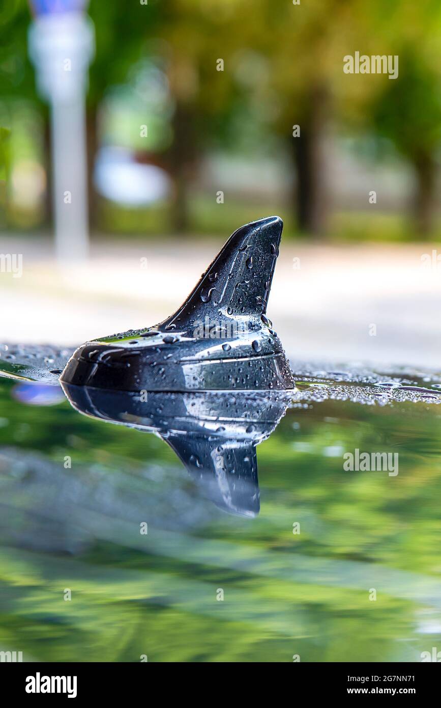 Antenna di navigazione per auto. Antenna GPS sul tetto dell'auto sotto la pioggia. Posizionare per il testo. Tema per la pubblicità di elettronica auto o auto elettriche. Foto Stock