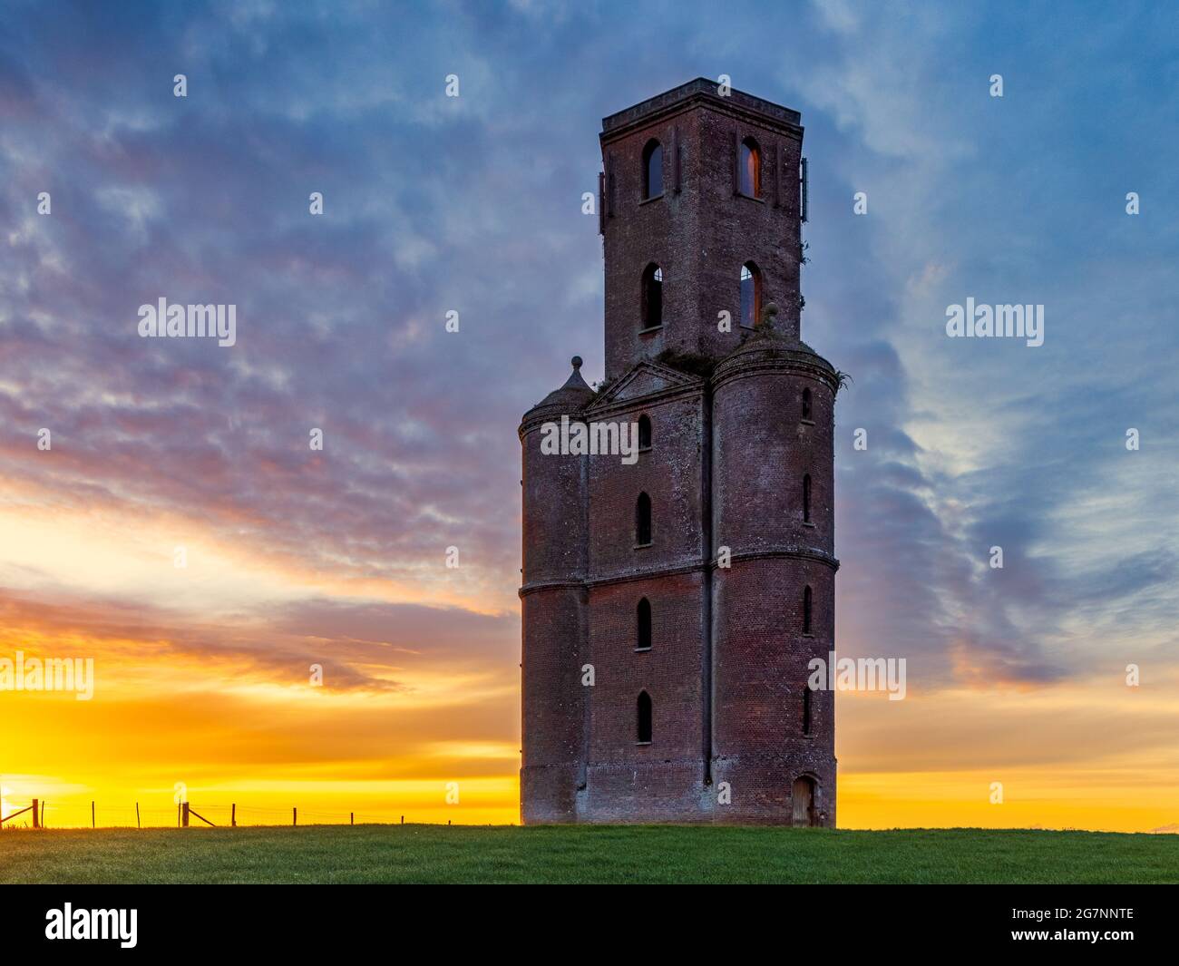 Sunrise at Horton Tower in Dorset, un osservatorio gotico in mattoni rossi a cinque piani di 43 metri di altezza / follia disegnata da Humphrey Sturt nel 18 ° secolo. Foto Stock