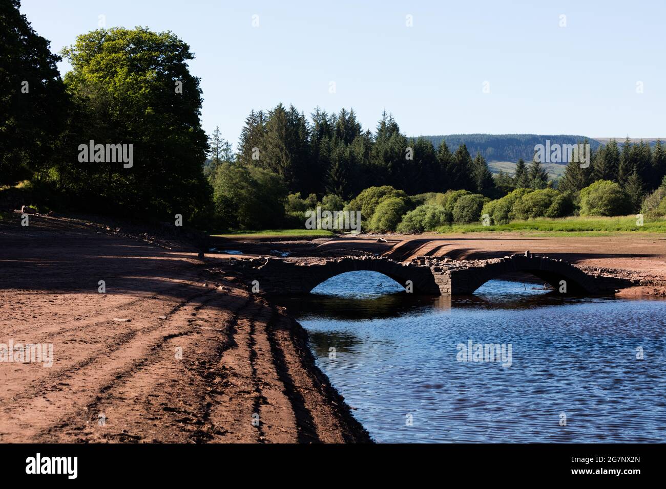 Llwyn Onn Reservoir, Merthyr Tydfil, Galles del Sud, Regno Unito. 15 luglio 2021. Tempo nel Regno Unito: Livelli di acqua inferiori al normale a causa del calore, hanno scoperto il ponte Pont Yr DAF, di solito sott'acqua. È stato costruito prima che il serbatoio fosse costruito. Credit: Andrew Bartlett/Alamy Live News Foto Stock