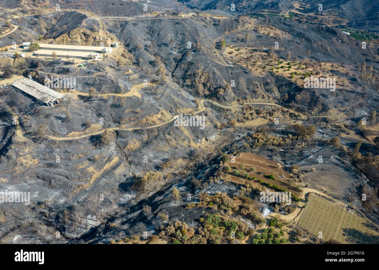 Fuoco di montagna con terra di agricoltura bruciata e foresta. Disastro dell'ambiente Cipro. Foto Stock