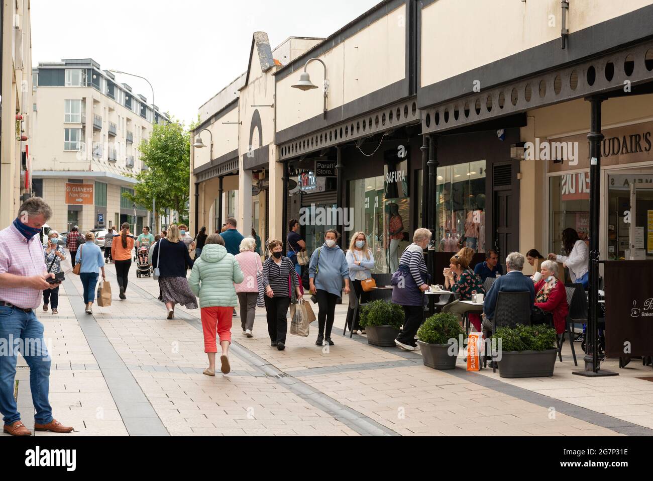 Le persone che indossano maschere di protezione che acquistano su Abbey Street a Tralee, County Kerry, Irlanda a partire da giugno 2021 Foto Stock