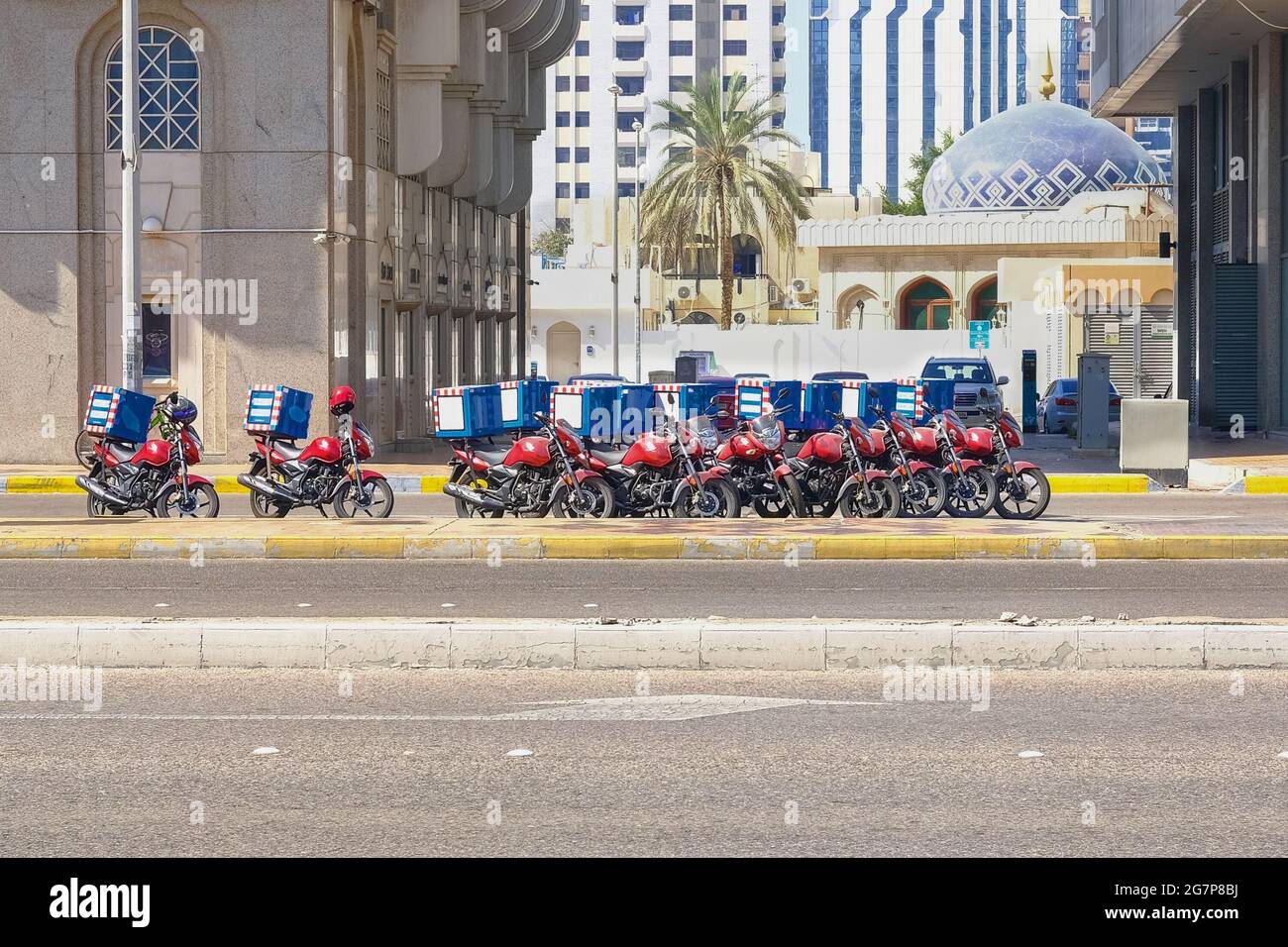 Servizio di consegna di cibo negli Emirati Arabi Uniti. Gruppo di motociclette parcheggiate in un parcheggio speciale sulla strada in attesa dell'ordine e della consegna ai clienti. Foto Stock