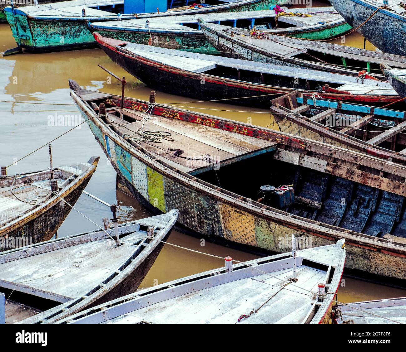 Diverse barche colorate fatte a mano tutte insieme nel fiume Gange, Varanasi, India Foto Stock