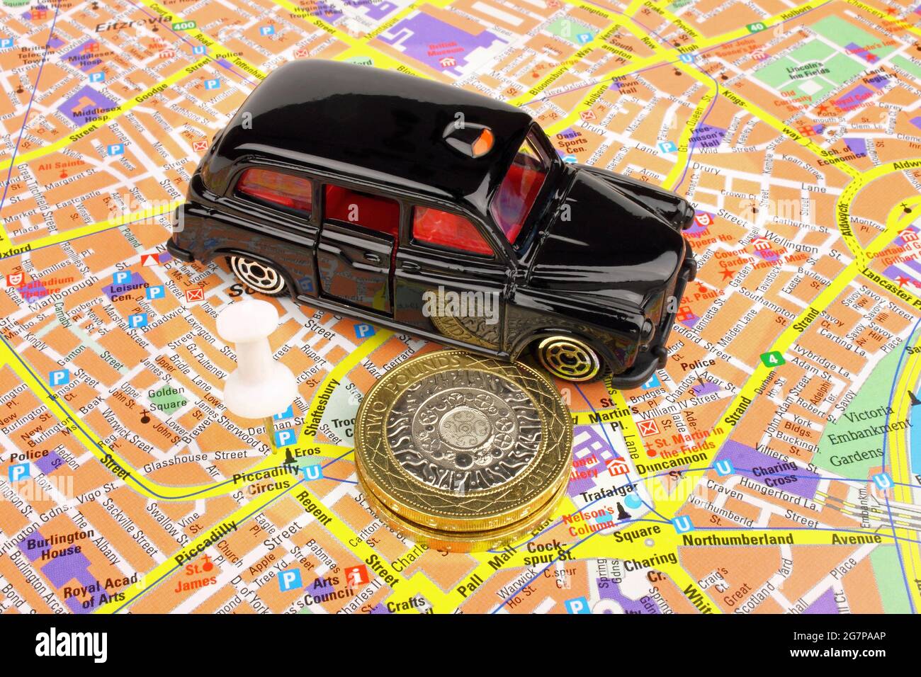 Un taxi nero, su una mappa della città di Londra. Foto Stock