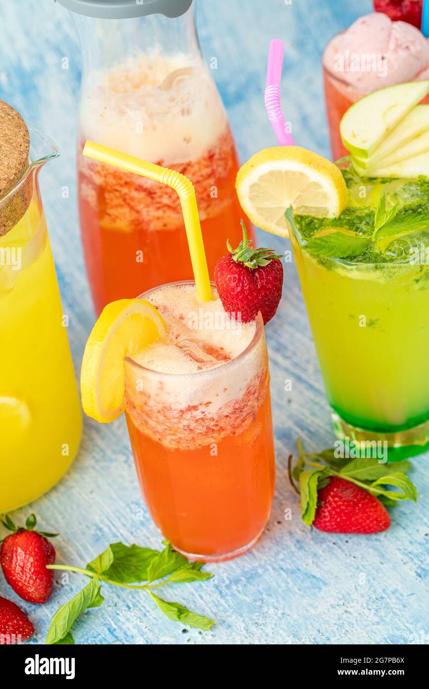 limonata rinfrescante con limone, fragola e menta su sfondo blu Foto Stock