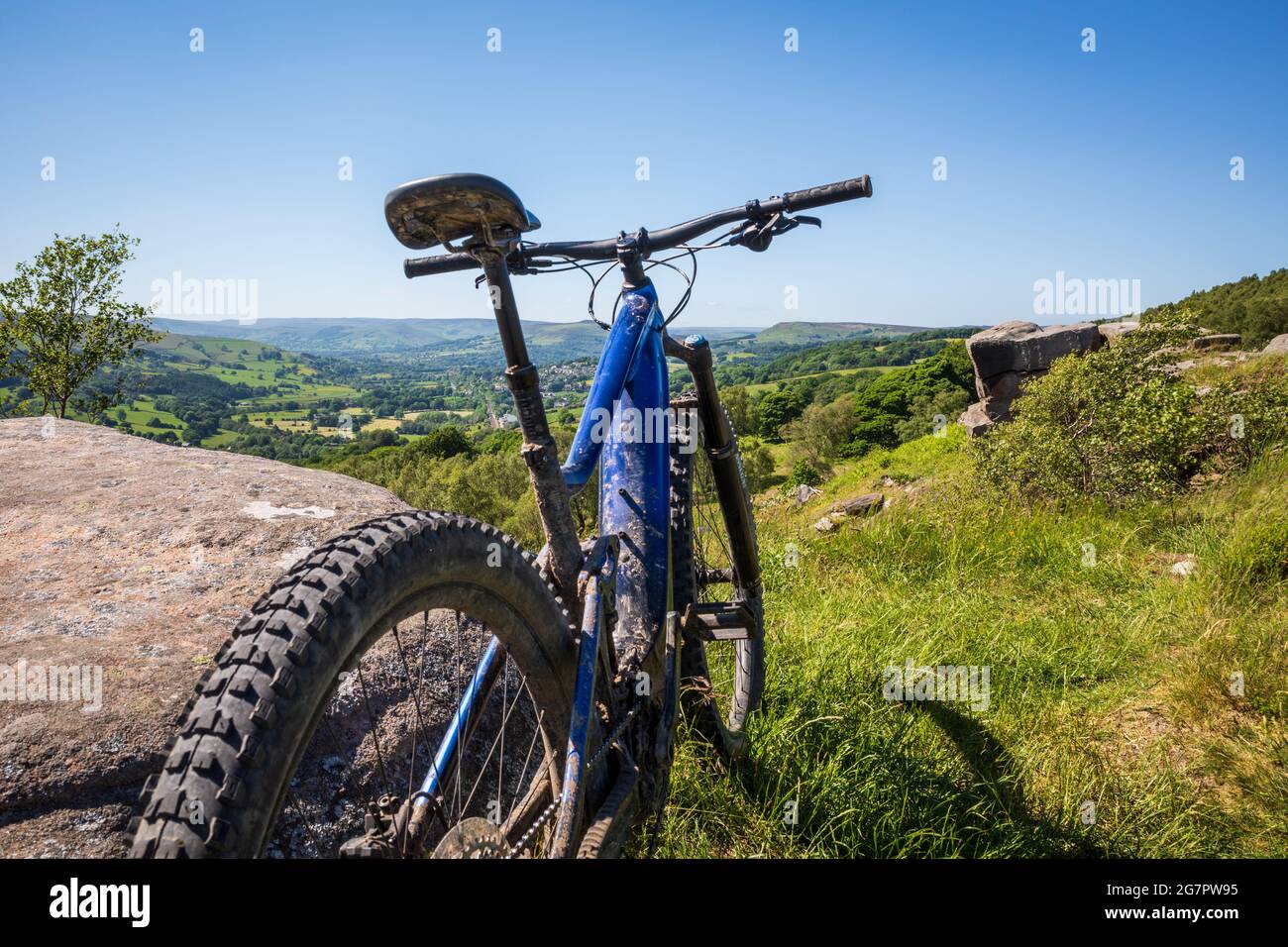 Primo piano su una bicicletta blu sportiva in piedi in collina verde in una giornata di sole Foto Stock