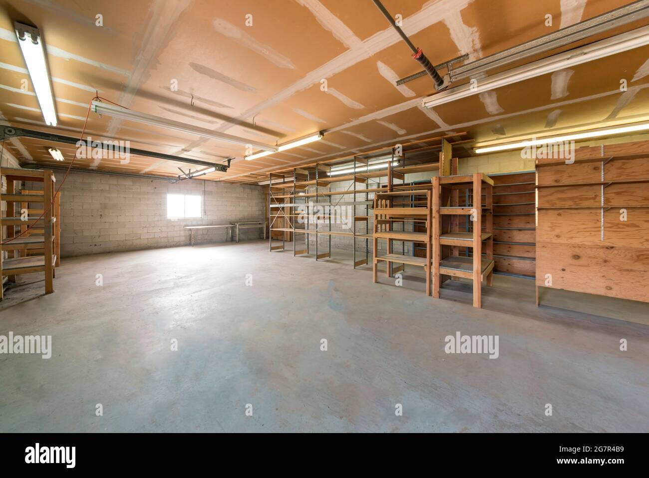 Interno incompiuto del garage con blocchi di cemento e un soffitto con segni bianchi. Foto Stock
