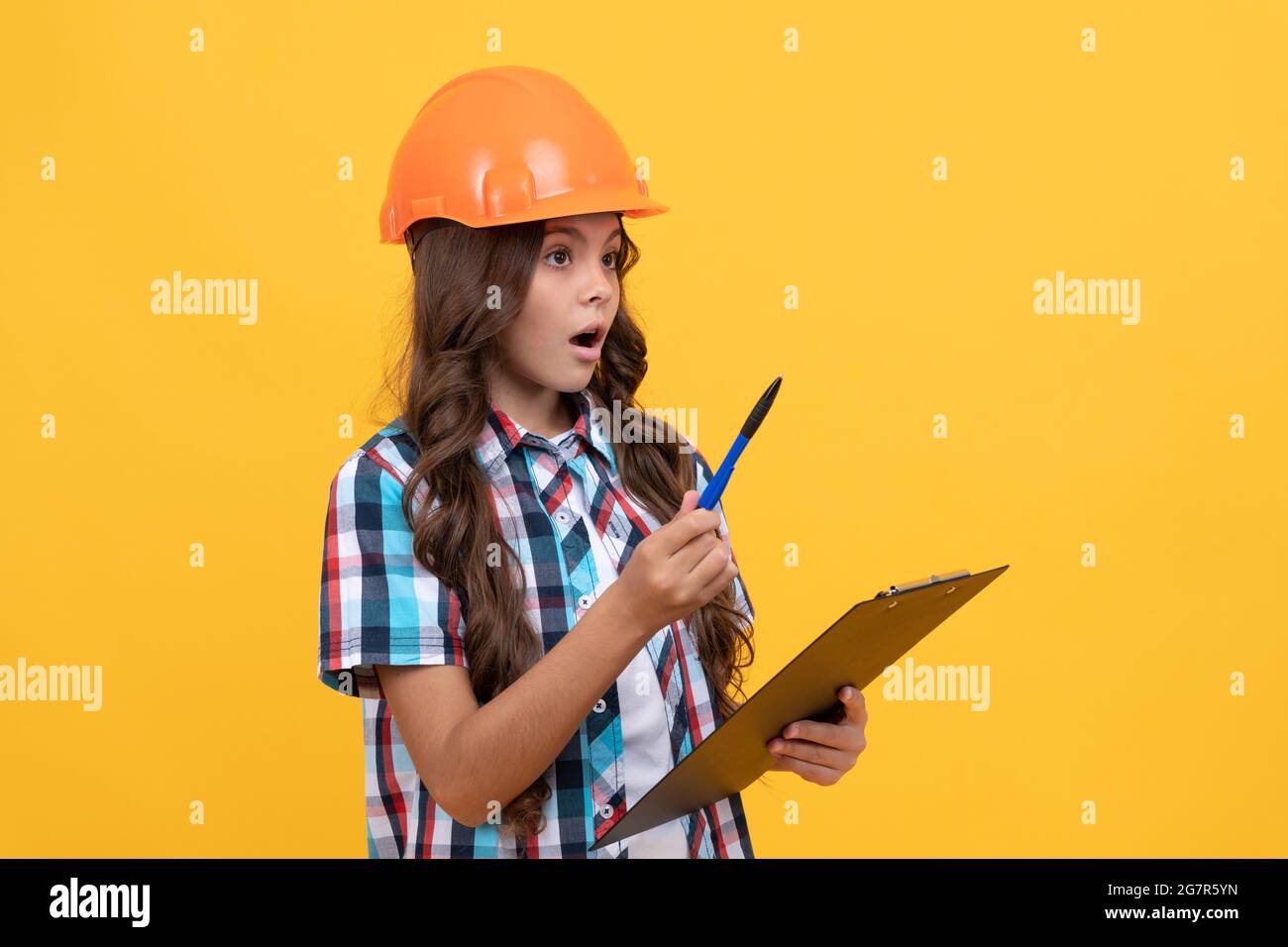 sicurezza lavoro expertise. stupito ragazza in elmetto protettivo prendere appunti. Foto Stock