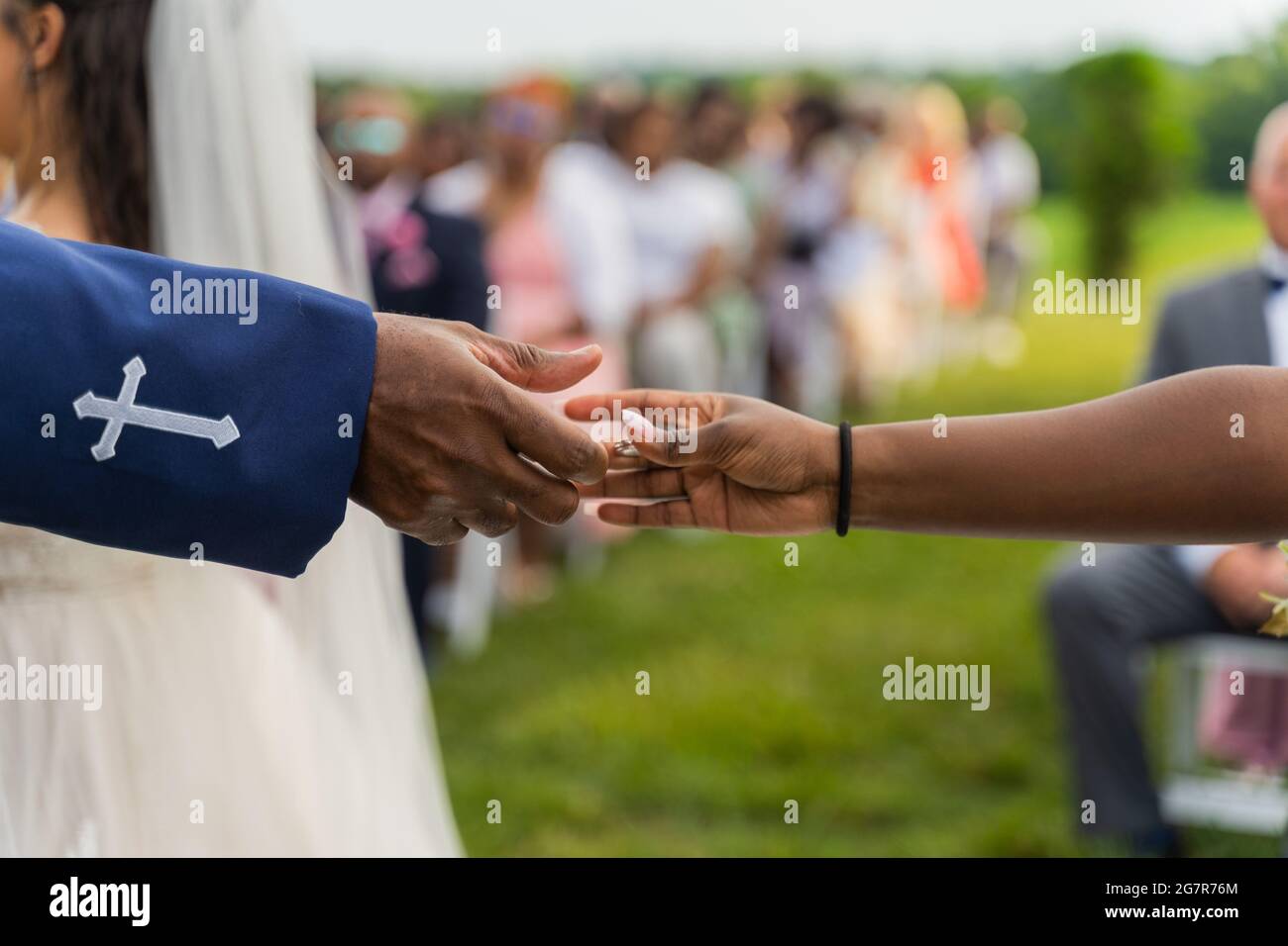 Primo piano di mani di un sacerdote e di una donna in un background di cerimonia nuziale Foto Stock