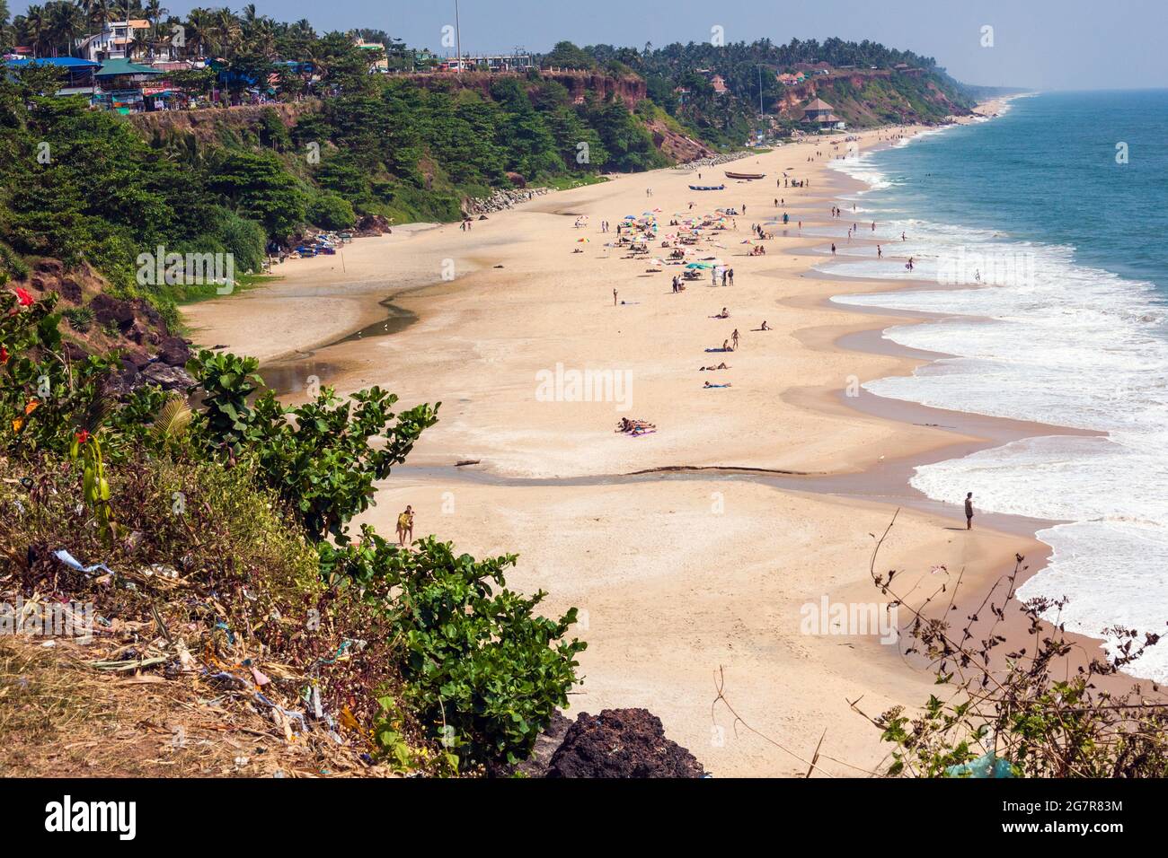 Vista dall'alto della scogliera a Varkala con i turisti prendere il sole sulla spiaggia sotto, Kerala, India Foto Stock