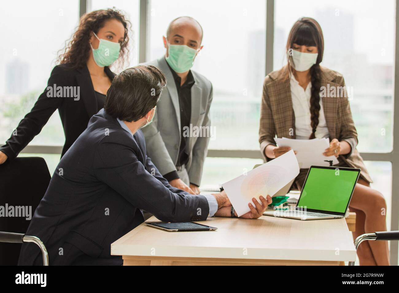 Uomini d'affari di gruppo che si riunono in ufficio indossare una maschera medica proteggere il cofirus 19 o Coronavirus Foto Stock