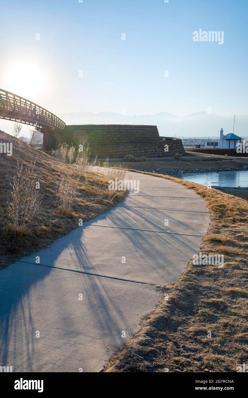Percorso curvo cieco in mezzo alla collina con erba contro la luce solare Foto Stock
