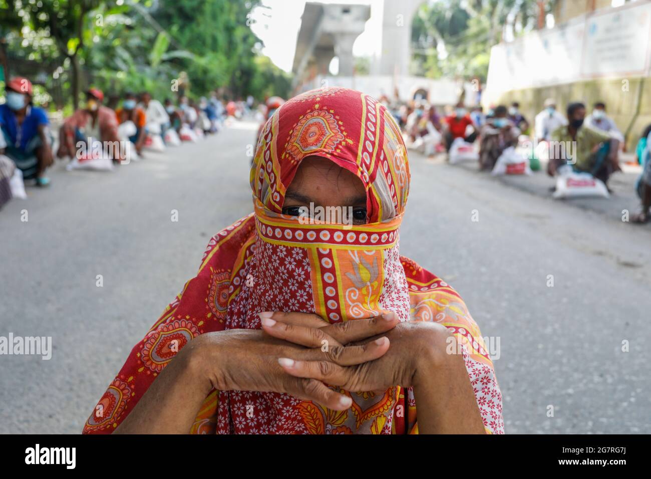 Le persone a basso reddito ricevono gli alimenti di emergenza forniti dall'esercito del Bangladesh durante il blocco nazionale per frenare la diffusione del coronavirus (COVID-19) Foto Stock